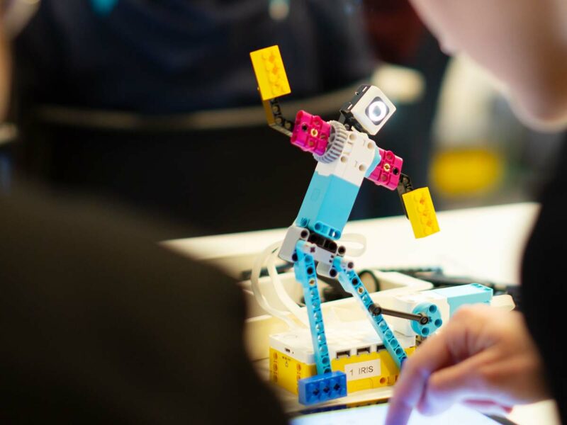 en robot gjord av blå, vita och rosa lego som ett barn har programmerat.