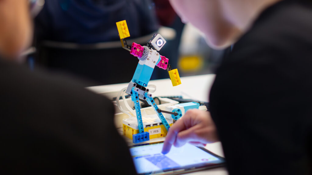 en robot gjord av blå, vita och rosa lego som ett barn har programmerat.