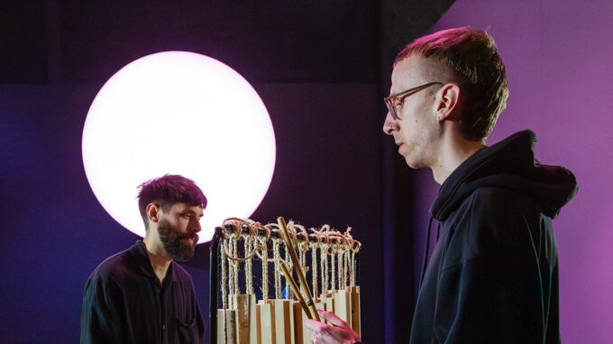 Två killar som spelar träinstrument i Skogen