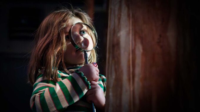 barn med förstoringsglas som tittar på ett träd