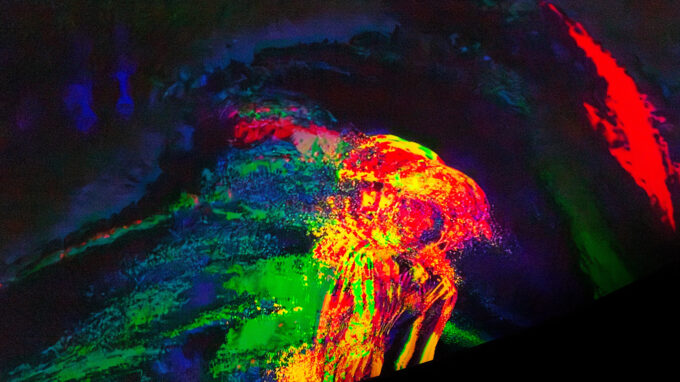 en projektion av färger och form som formas på en svart duk