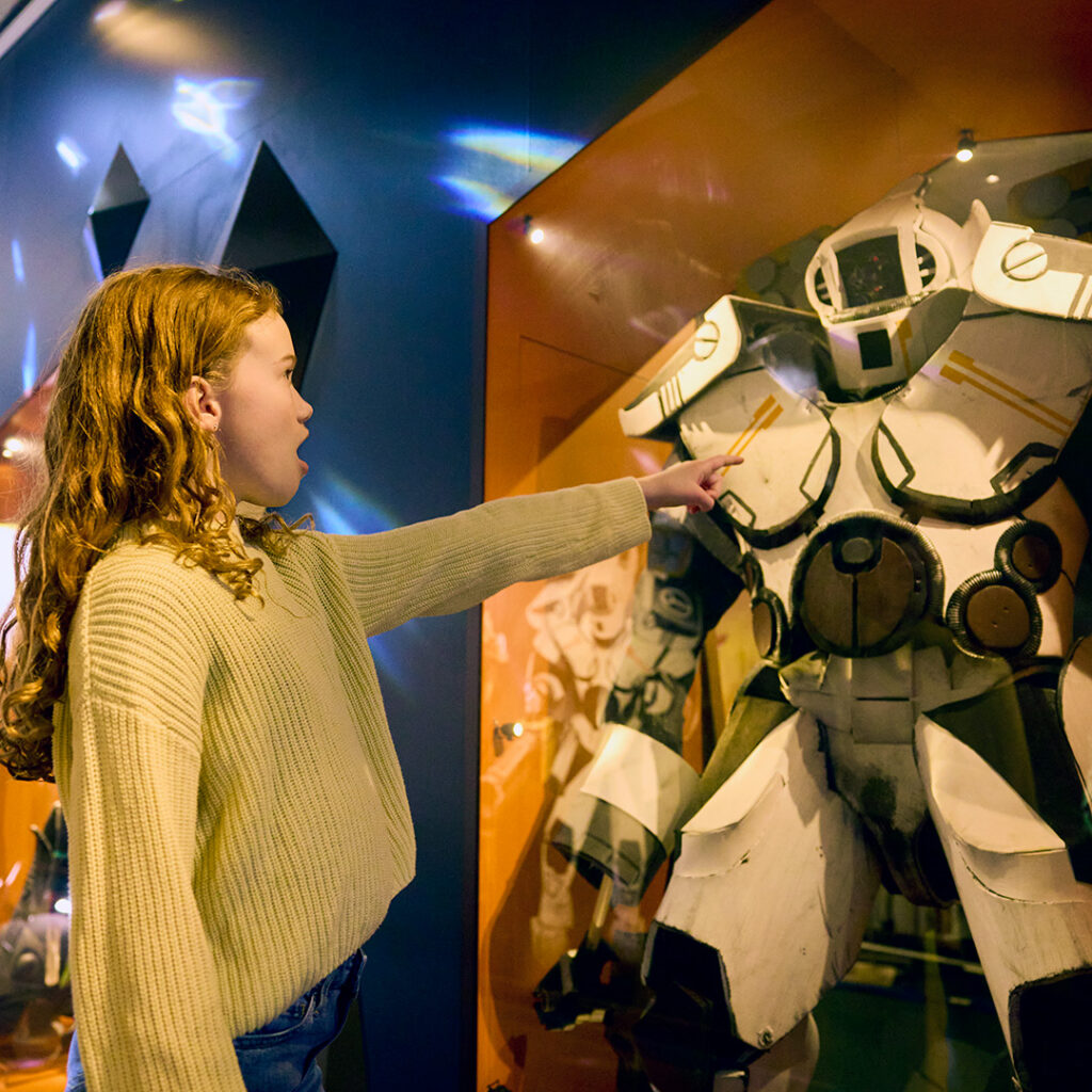 Flickar som tittar häpet och pekar på en robot i Play Beyond Play