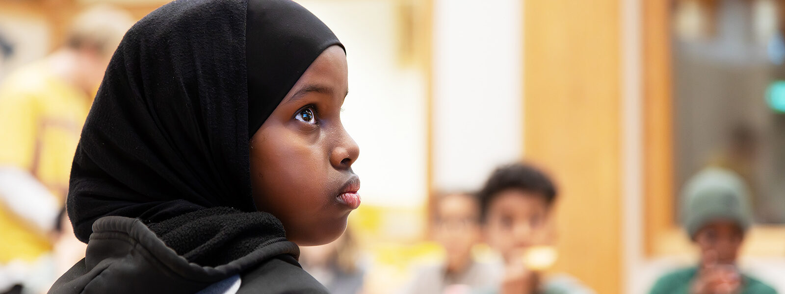 ung tjej tittar med nyfiken blick på pedagogen.