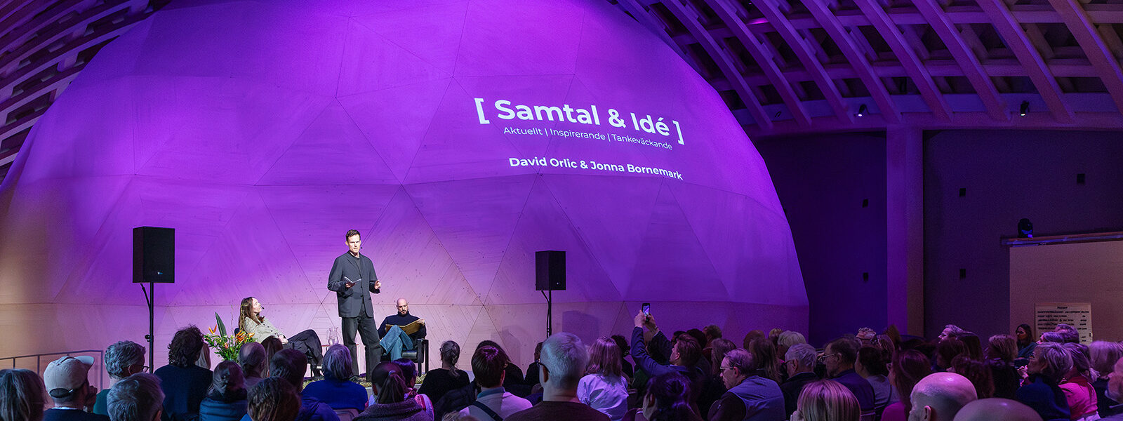 samtal och idé program med paneldeltagare och publik som sitter i Trähallen.