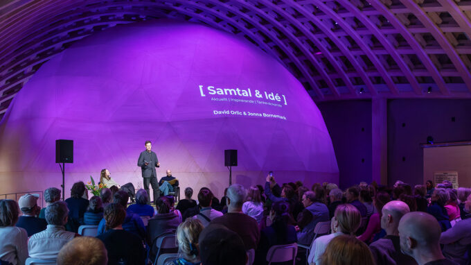 samtal och idé program med paneldeltagare och publik som sitter i Trähallen.